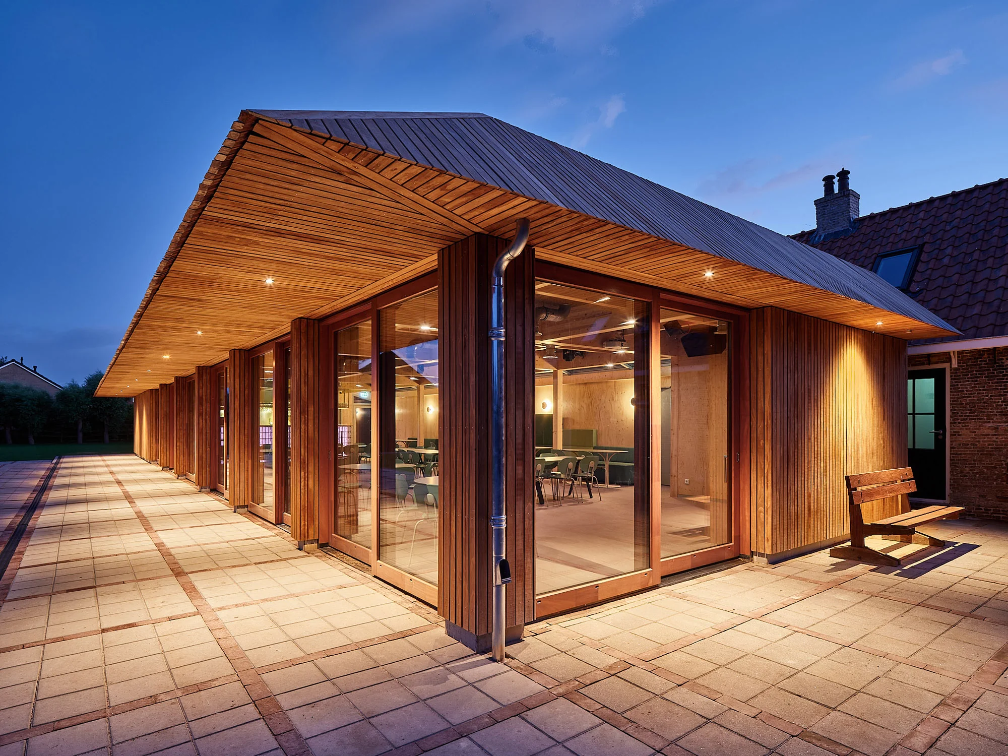Verlicht paviljoen van Het Molenhuis in de avond