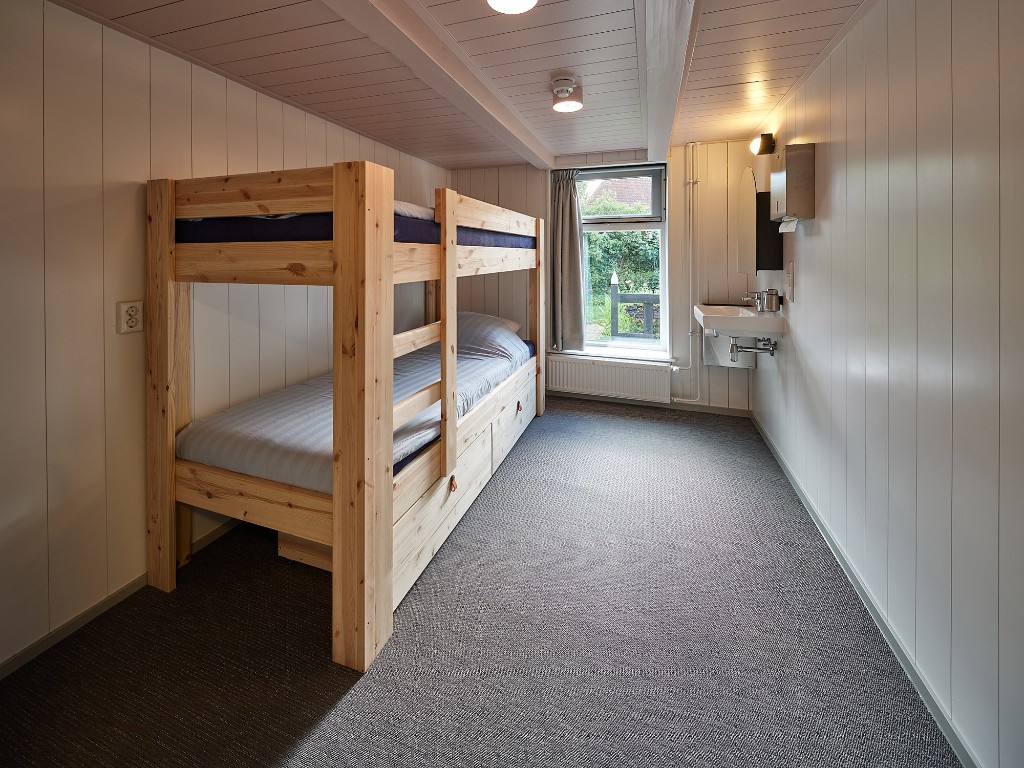 Slaapkamer met stapelbedden en groene muren in Het Molenhuis