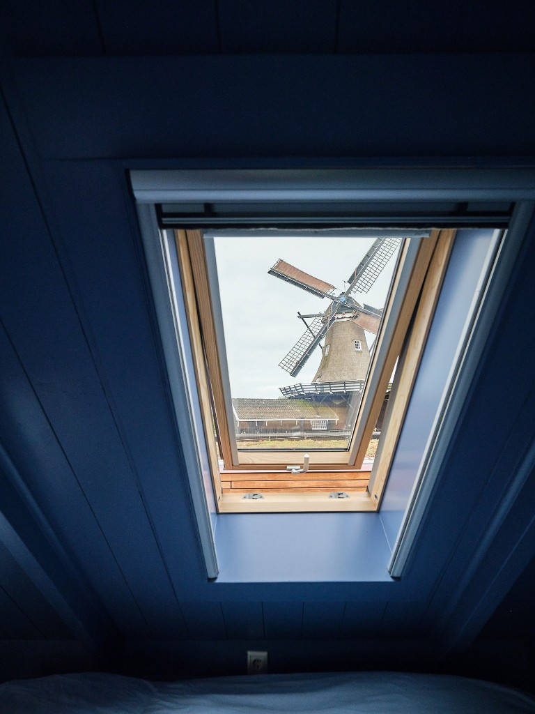 Uitzicht op de houtzaagmolen vanuit de blauwe zolderkamer in Het Molenhuis